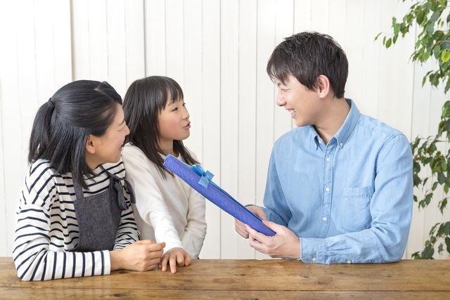 お父さんにプレゼントを渡す娘