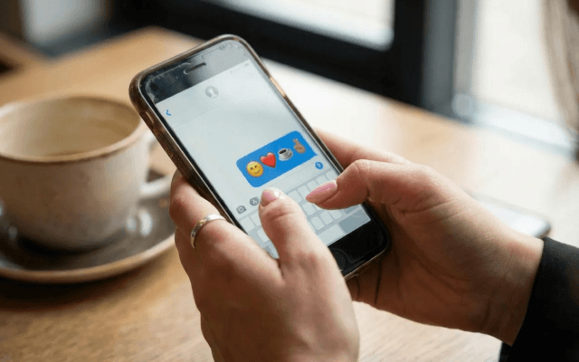 スマートフォンで絵文字入りメッセージを送ろうとしている女性