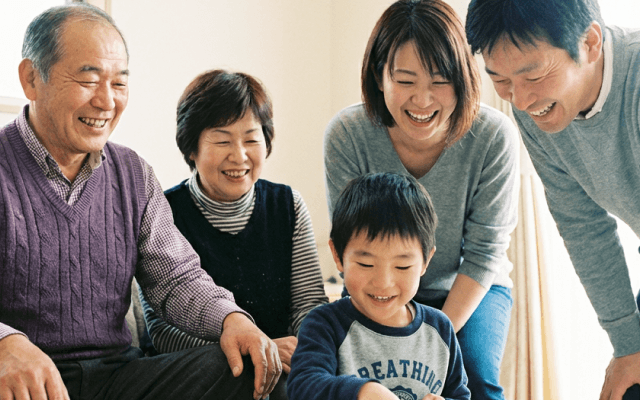 紫の風呂敷に包まれた贈り物を渡す女性